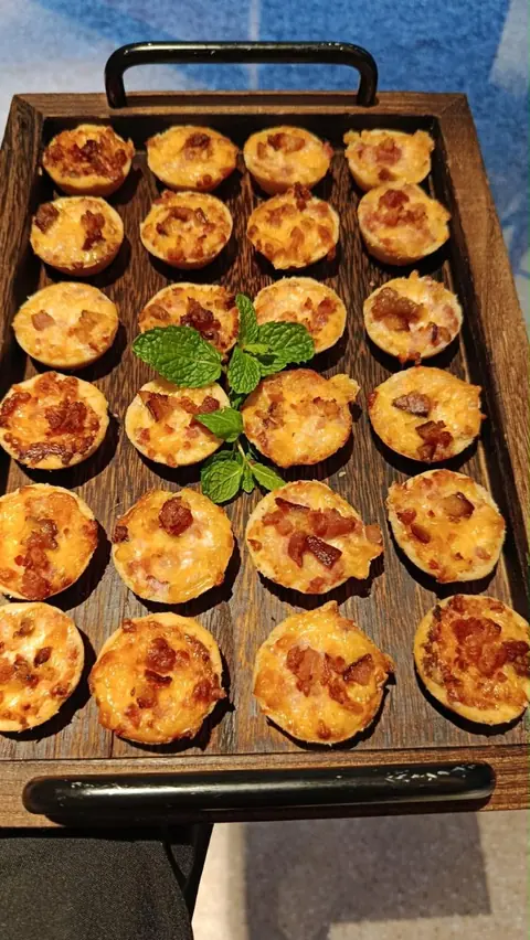 Finger food: mini quiches gratinadas em bandeja de madeira com ramo de hortelã